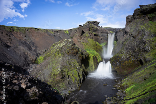 Beautiful smooth waterfall in Iceland on the hiking trail Fimmvorduhals in slow motion during evening 