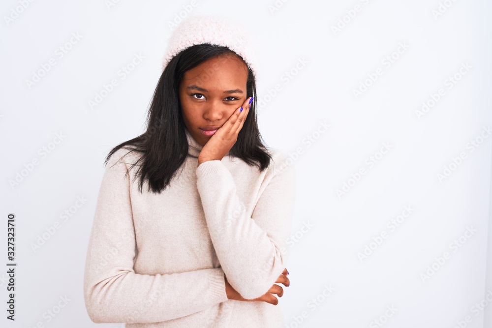 Beautiful young african american woman wearing turtleneck sweater and winter hat thinking looking tired and bored with depression problems with crossed arms. Beautiful young african american woman wearing turtleneck sweater and winter hat thinking looking tired and bored with depression problems with crossed arms.