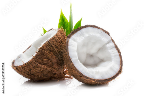Ripe coconut and its parts with green palm leaves close-up