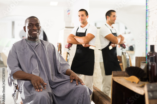 African man approving result of hairdresser work