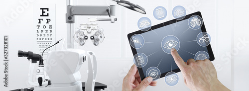 hands touch screen of digital tablet with ophthalmologist and optometrist icons symbols, ophthalmology and optometry equipment on background photo