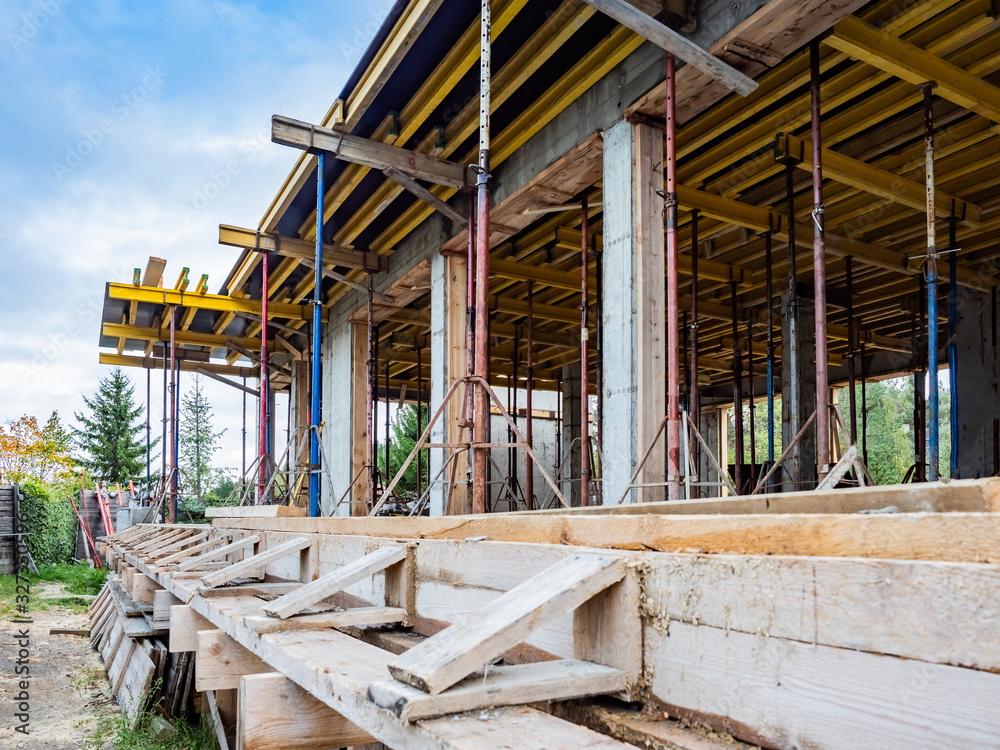 Fototapeta premium Construction site. Construction of a new cottage. Formwork of a new house. Construction work outside the city. Vacancies for builders. Implementation of the new house project.