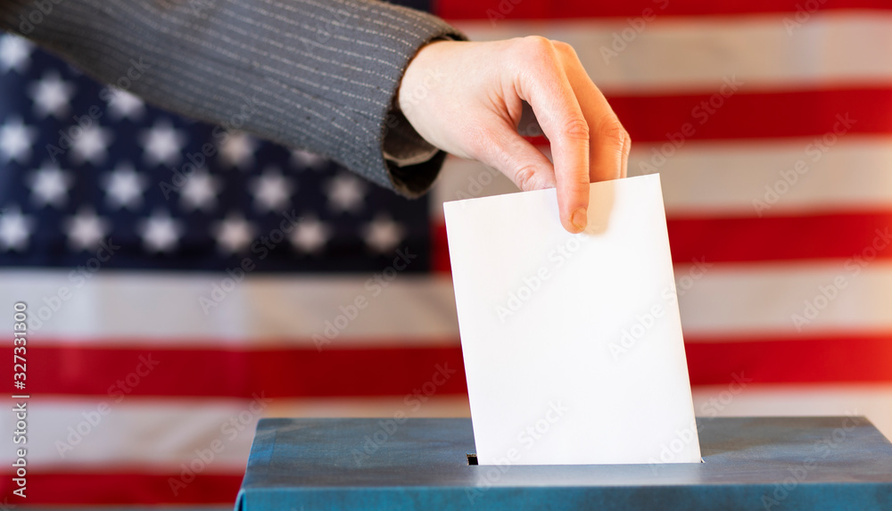 usa elections the hand of woman putting her vote in the ballot box usa elections the hand of woman putting her vote in the ballot box