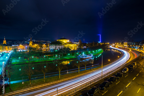 Obraz na płótnie Germany, Beautiful city saarbruecken in saarland by night with lots of cars and traffic driving alongside water of saar river, illuminated in magical atmosphere w salonie