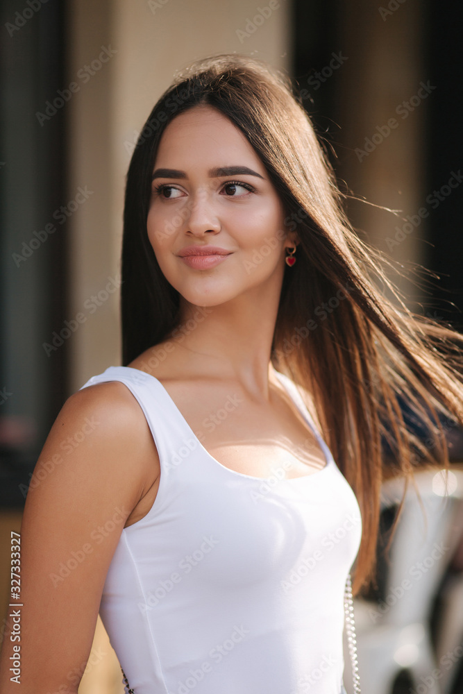 Fototapeta premium Portrait of beautiful brunette outside. Attractive young woman