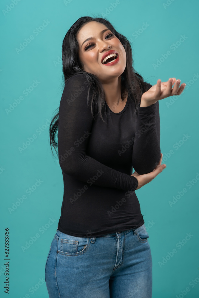 beautiful curvy asian woman with black top and blue jeans on turquoise background happy faces beautiful curvy asian woman with black top and blue jeans on turquoise background happy faces
