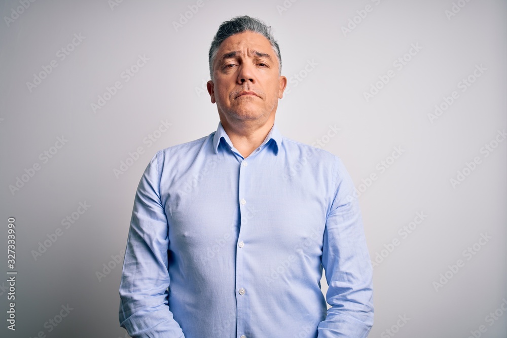 Middle age handsome grey-haired business man wearing elegant shirt over white background Relaxed with serious expression on face. Simple and natural looking at the camera. Middle age handsome grey-haired business man wearing elegant shirt over white background Relaxed with serious expression on face. Simple and natural looking at the camera.