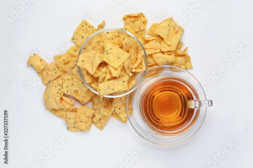 Keropok Tauhu tofu flower sugar chips with blackseed with cup of transparent licker tea photo