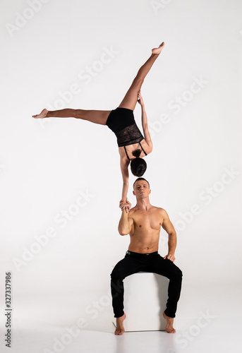 Photos Duo Of Acrobats Showing hand to hand Trick, Isolated On White