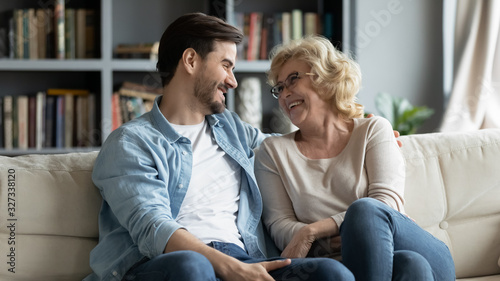 Fotografie Overjoyed mature mother and adult son have fun at home