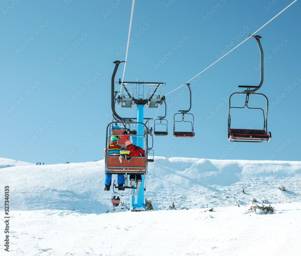 People using chairlift at mountain ski resort. Winter vacation People using chairlift at mountain ski resort. Winter vacation