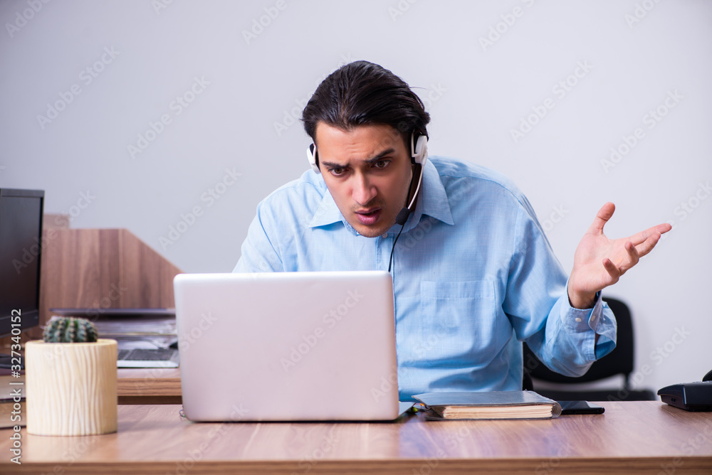 Call center operator working at his desk Call center operator working at his desk