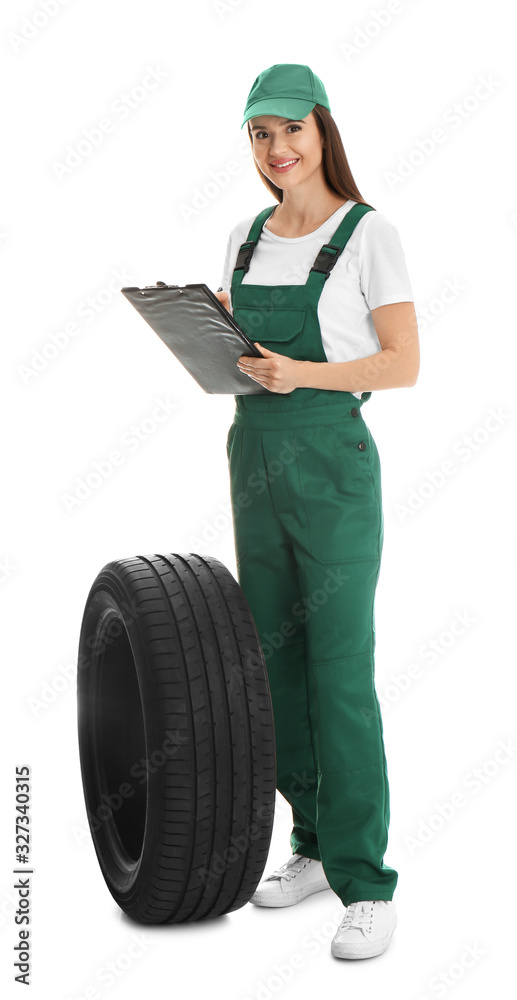 Fototapeta premium Professional auto mechanic with tire and clipboard on white background