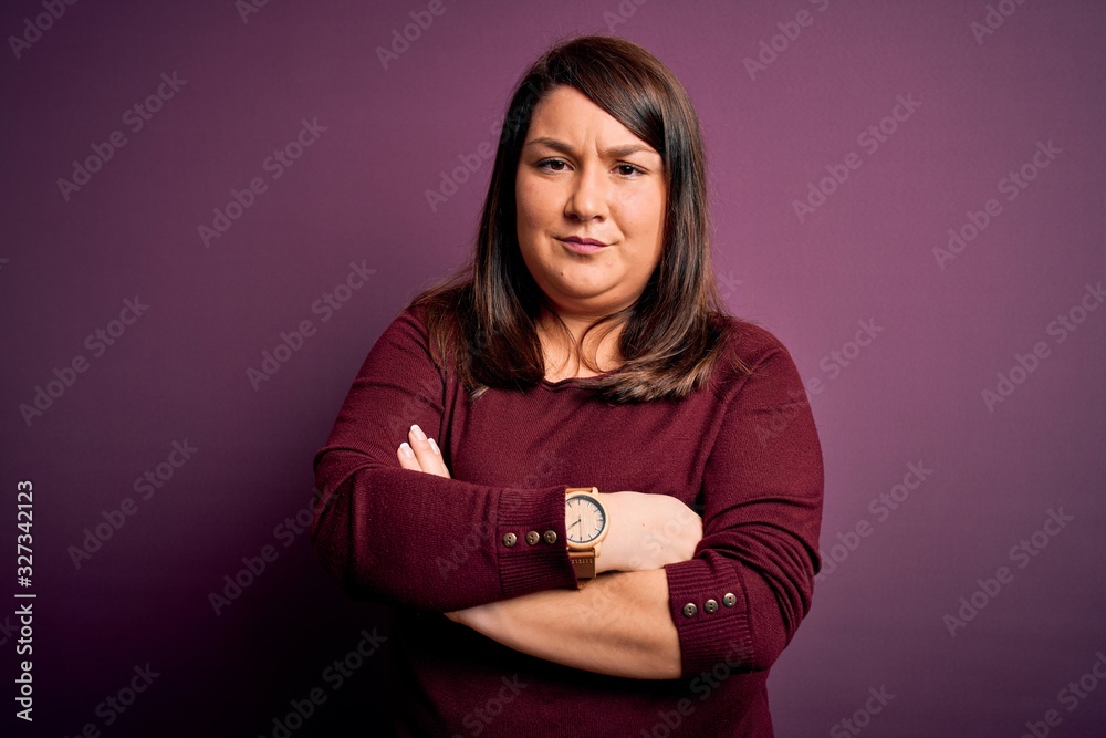 Obraz premium Beautiful brunette plus size woman wearing casual sweater over isolated purple background skeptic and nervous, disapproving expression on face with crossed arms. Negative person.