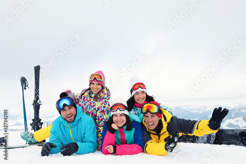 Group of friends with equipment in snowy mountains. Winter vacation