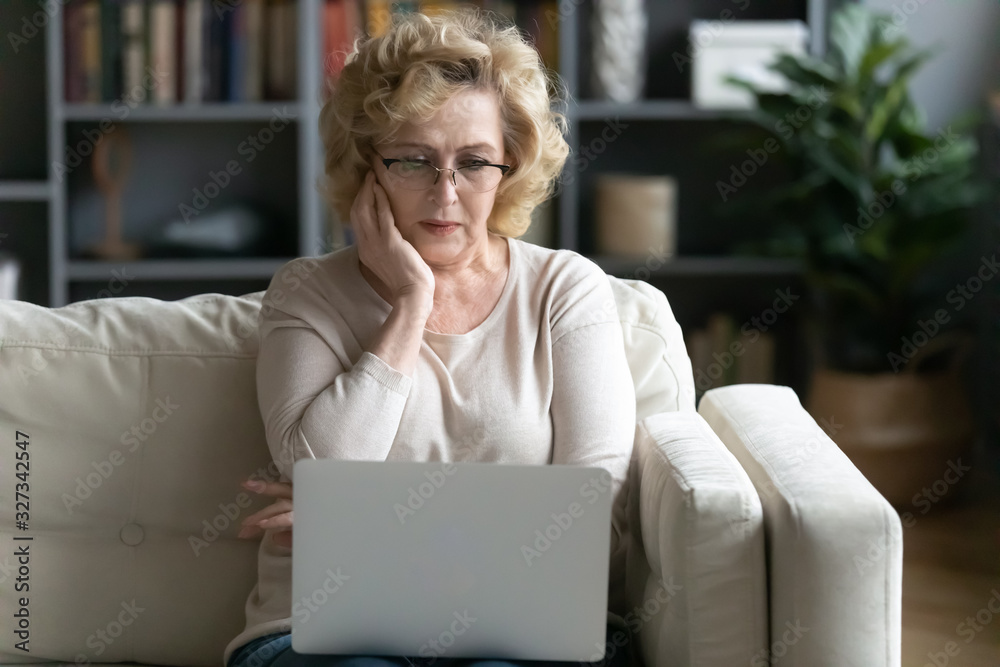 Anxious senior woman read bad news on laptop Anxious senior woman read bad news on laptop