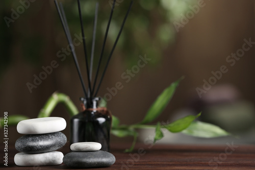 Spa stones on wooden table indoors. Space for text