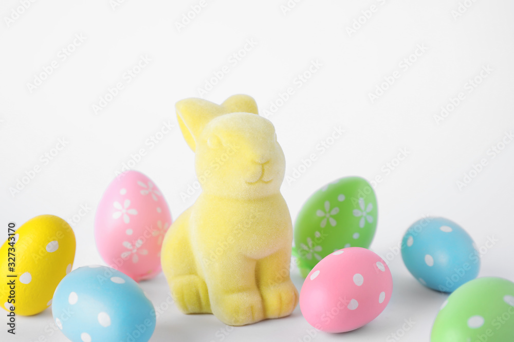 Easter bunny toy and dyed eggs on white background Easter bunny toy and dyed eggs on white background