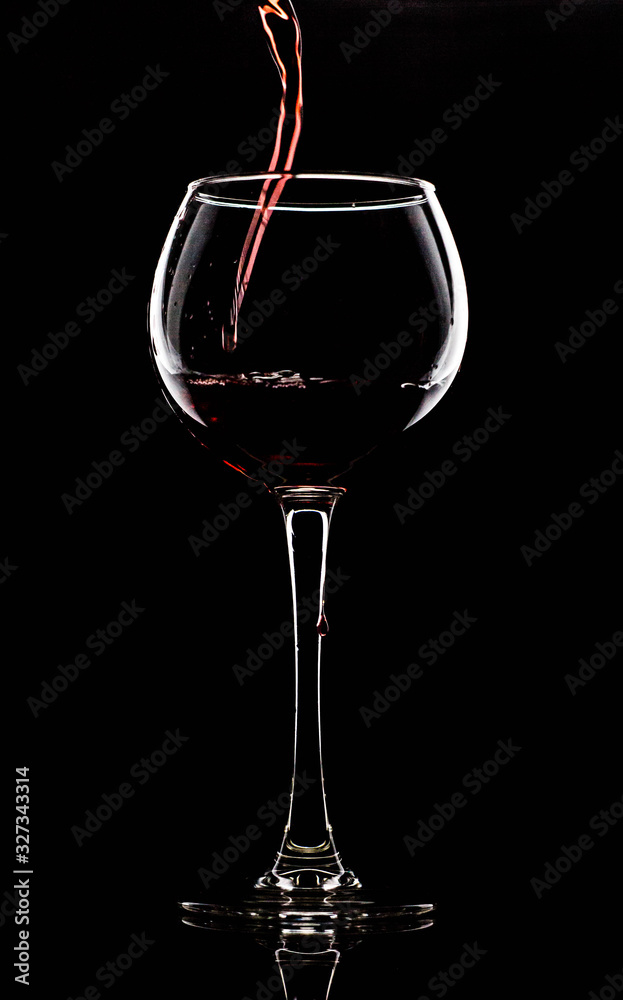 Silhouette of a glass on a black background, a red drink is poured on top Silhouette of a glass on a black background, a red drink is poured on top