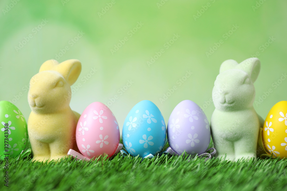 Easter bunnies and painted eggs on green grass