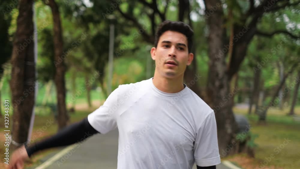 Runner man running in park exercising outdoors fitness . Female jogger running on road and street in park with trees. Runner doing outdoor cardio exercise.lose Up Following Shot From Steady Cam. Runner man running in park exercising outdoors fitness . Female jogger running on road and street in park with trees. Runner doing outdoor cardio exercise.lose Up Following Shot From Steady Cam.