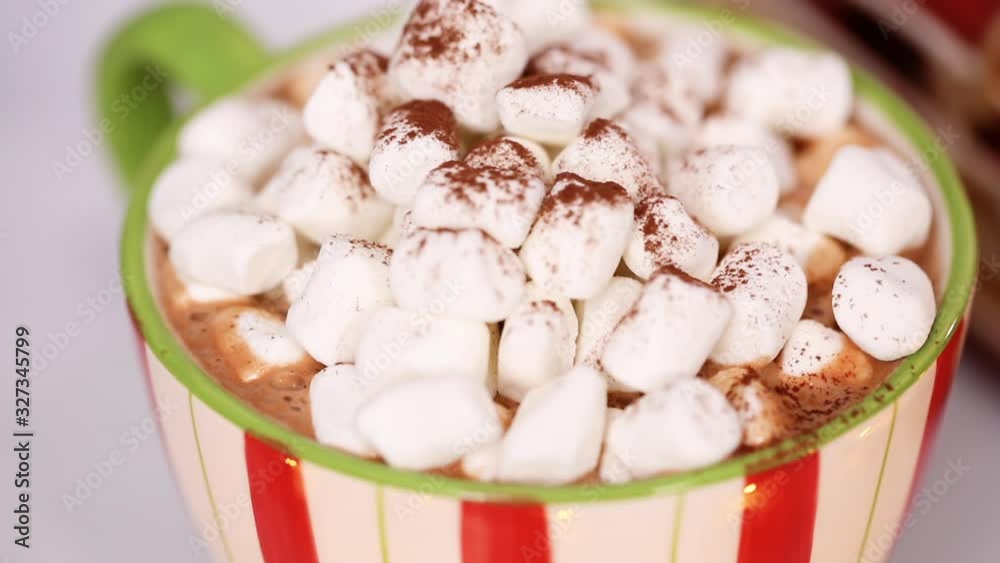 Pouring American hot chocolate into the mug.