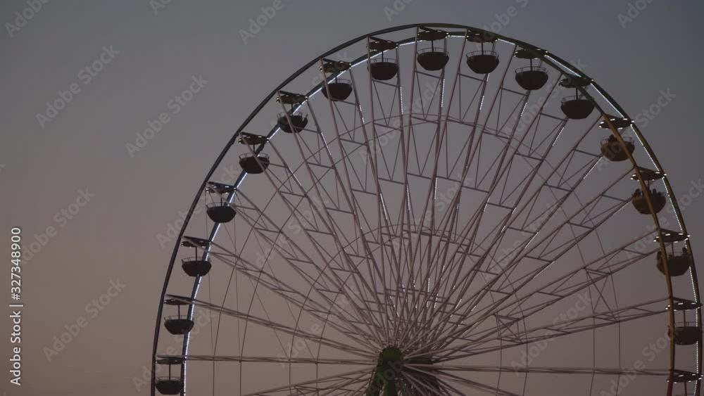 Colorful ferris wheel in the city park at evening. Colorful ferris wheel in the city park at evening.