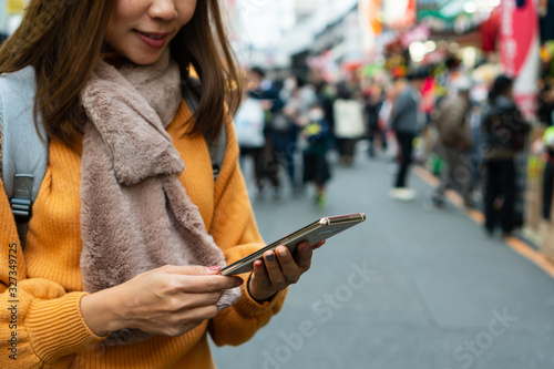 Young traveller women using smart phone to searching the map at the street market ; close up. photo