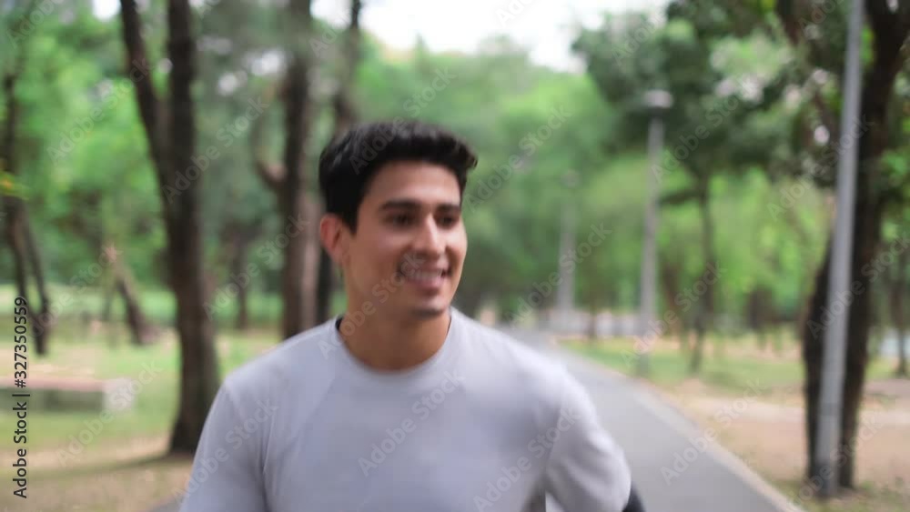 Runner man running in park exercising outdoors fitness . Female jogger running on road and street in park with trees. Runner doing outdoor cardio exercise.lose Up Following Shot From Steady Cam. Runner man running in park exercising outdoors fitness . Female jogger running on road and street in park with trees. Runner doing outdoor cardio exercise.lose Up Following Shot From Steady Cam.
