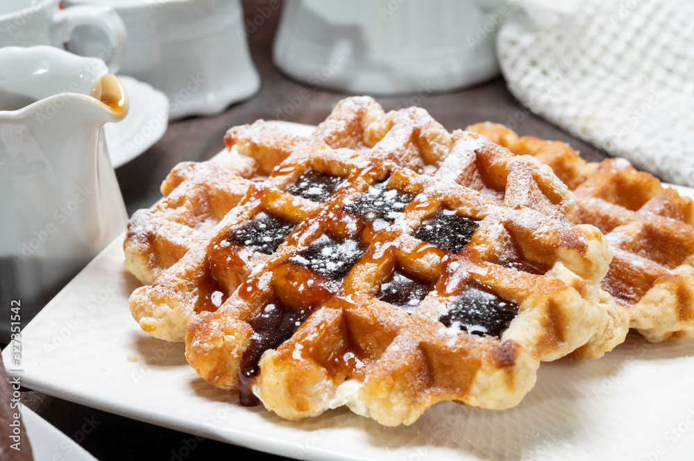 Tasty Belgian dessert, Brussels waffles with syrup and white sugar powder Tasty Belgian dessert, Brussels waffles with syrup and white sugar powder