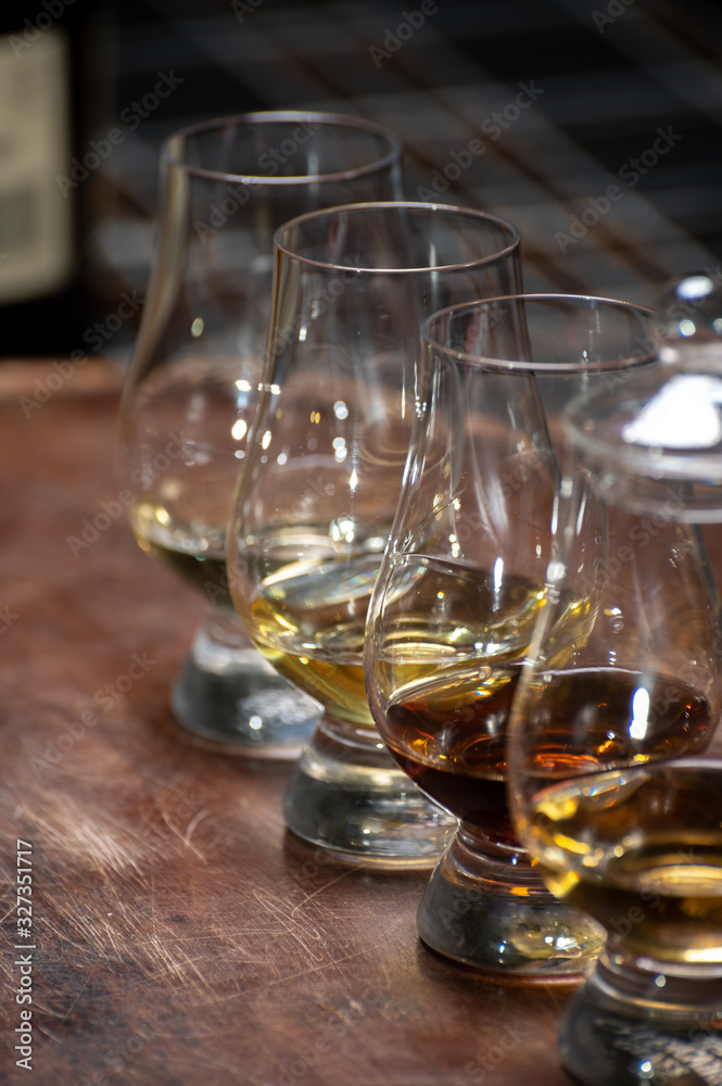 Tasting of flight of Scotch whisky from special tulip-shaped glasses on distillery in Scotland, UK Tasting of flight of Scotch whisky from special tulip-shaped glasses on distillery in Scotland, UK