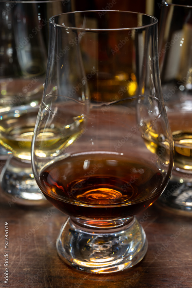 Tasting of flight of Scotch whisky from special tulip-shaped glasses on distillery in Scotland, UK Tasting of flight of Scotch whisky from special tulip-shaped glasses on distillery in Scotland, UK