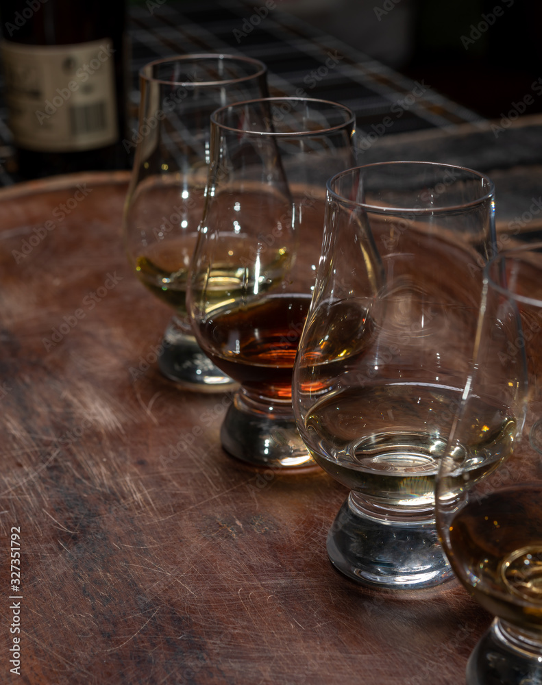 Obraz premium Tasting of flight of Scotch whisky from special tulip-shaped glasses on distillery in Scotland, UK