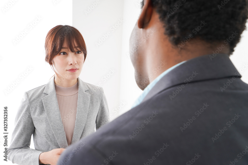 オフィスで意見交換をする2人のビジネスパーソン