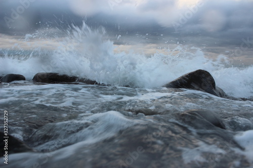 Stormy sea. Wave and stones. Drops on lens