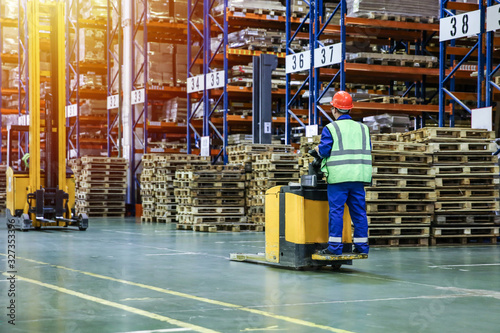 Bilde på lerret Electric pallet truck with worker in warehouse in motion