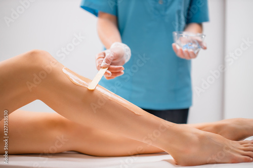 professional doctor applying special moisturiser on legs before using ipl machine. hair removal  epilation  hairless  soft and smooth skin concept
