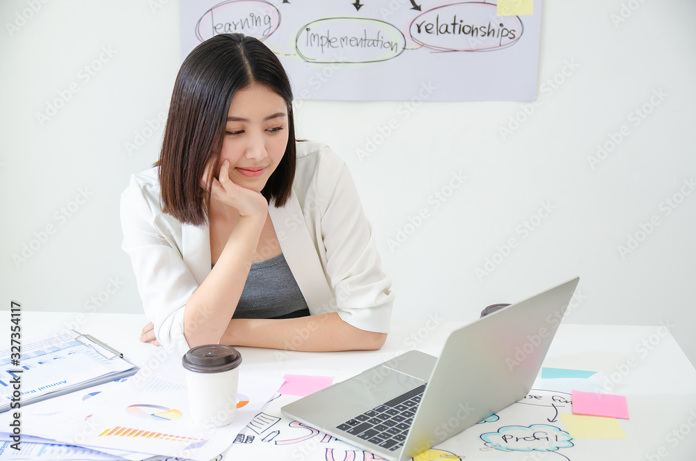 Smiling beautiful asian woman celebrate with laptop happy for success working. Agile for startup small business concept at modern office or co-working space with copy space for label text Smiling beautiful asian woman celebrate with laptop happy for success working. Agile for startup small business concept at modern office or co-working space with copy space for label text