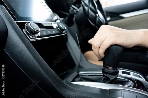 Closeup image of female driver shifting automatic gear stick while driving car. Smart wife can drive car