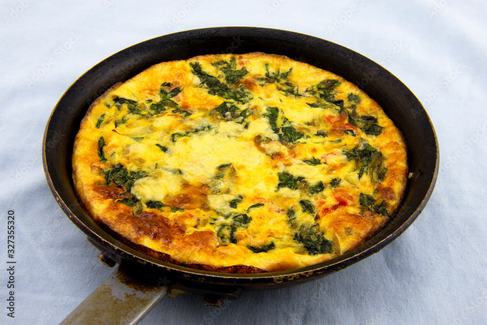 Frittata made of eggs, bacon, cheese and spinach