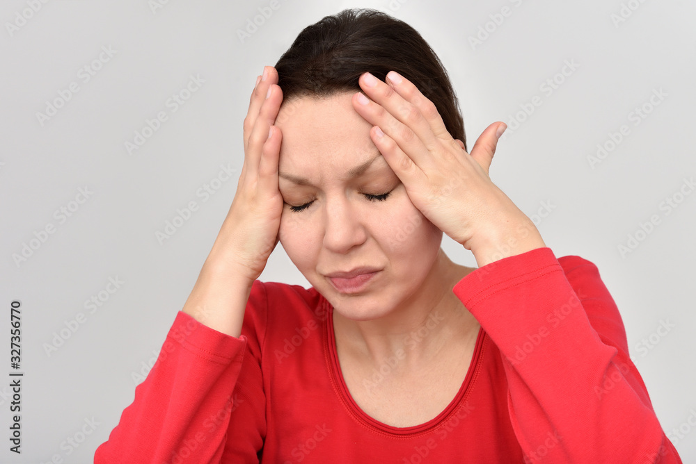 Woman with headache and closed eyes holding her head. Isolated on the background. Woman with headache and closed eyes holding her head. Isolated on the background.