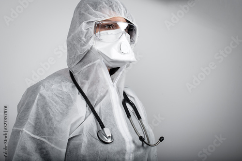 operatore sanitario con maschera, occhiali e tuta di protezione con stetoscopio photo