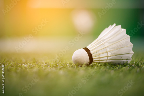 shuttlecock on green gress court  warm light 