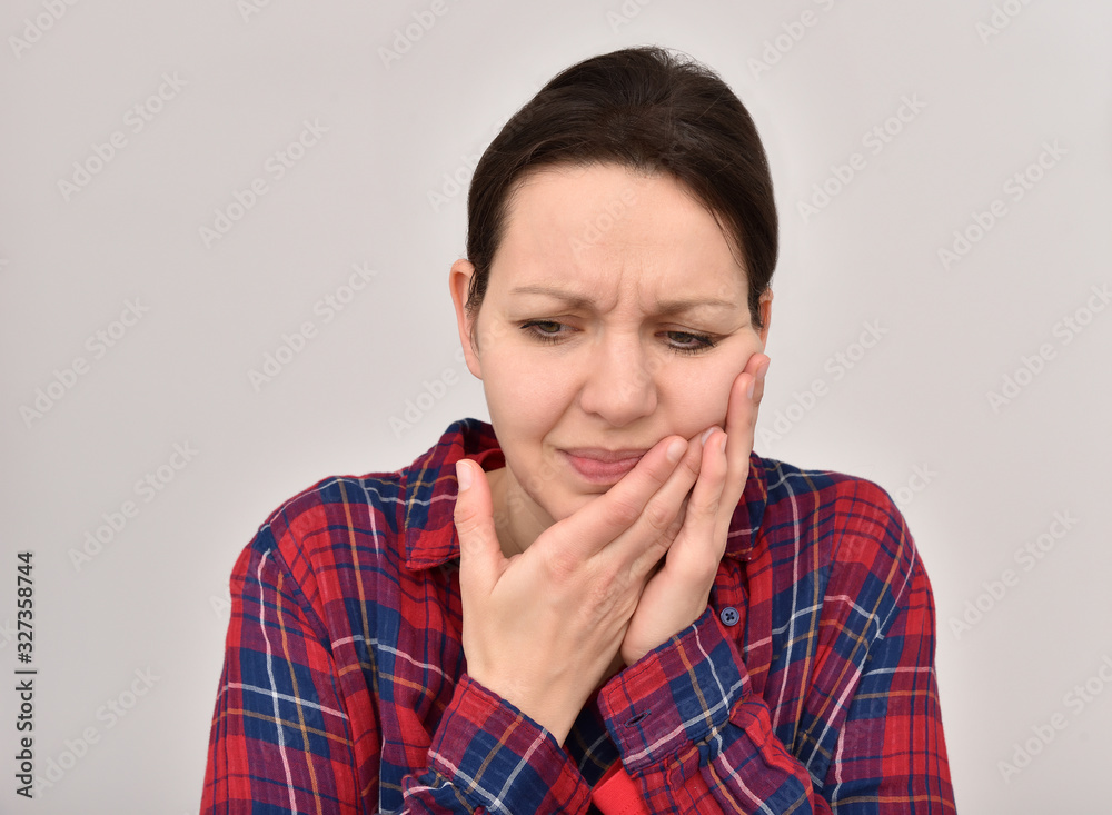 Woman with toothache and closed eyes holding her cheek. Isolated on the background. Woman with toothache and closed eyes holding her cheek. Isolated on the background.