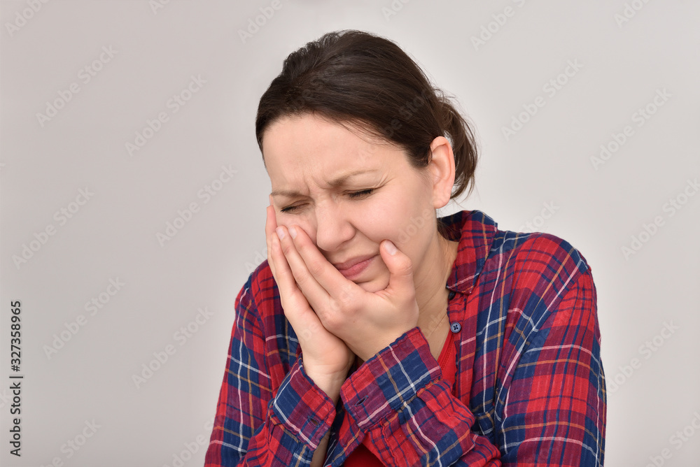 Woman with toothache and closed eyes holding her cheek. Isolated on the background. Woman with toothache and closed eyes holding her cheek. Isolated on the background.