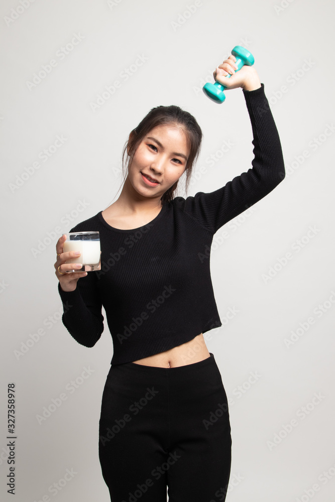Healthy Asian woman drinking a glass of milk and dumbbell. Healthy Asian woman drinking a glass of milk and dumbbell.