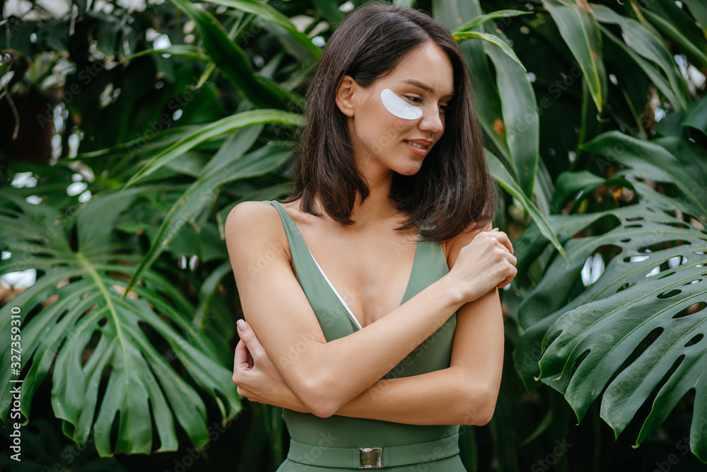 neat sensual caucasian young woman in forest, enjoy being close to nature, use organic cosmetics such as patches under eyes, care of face skin. natural beauty concept