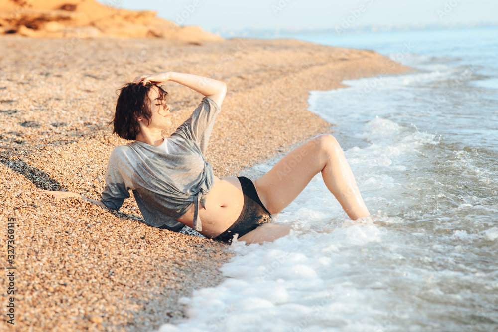 Young girl sunbathing on the beach. Concept of rest, lifestyle and good mood.