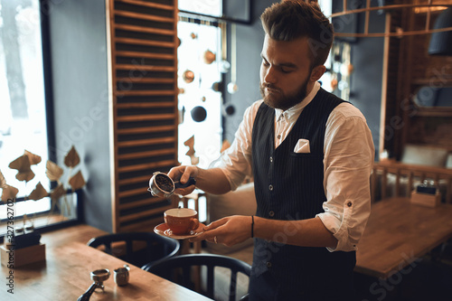 young man in fashion suit learning to make coffee, close up photo.