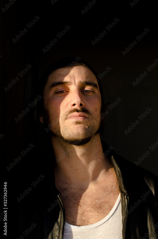 Obraz premium man with a goatee is in the shadows with a solemn look